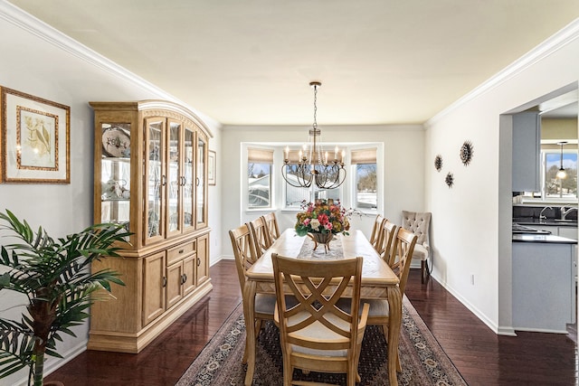 dining room featuring baseboards, a chandelier, dark wood finished floors, and crown molding