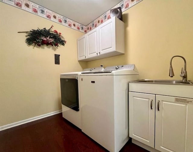 laundry room featuring a sink, baseboards, washer and dryer, cabinet space, and dark wood-style floors