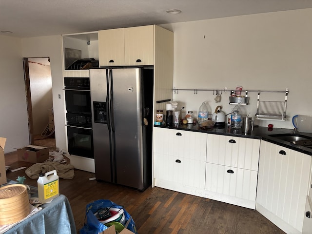 kitchen with dark hardwood / wood-style flooring, stainless steel fridge with ice dispenser, double oven, and sink