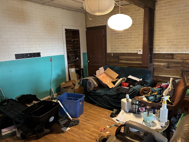 interior space with hardwood / wood-style flooring and brick wall