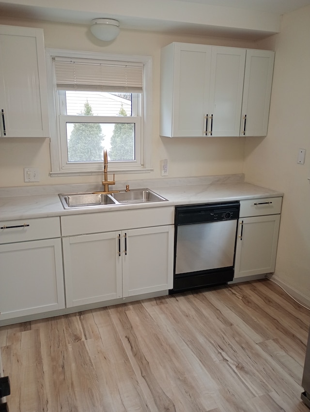 kitchen featuring a sink, white cabinets, light countertops, and stainless steel dishwasher