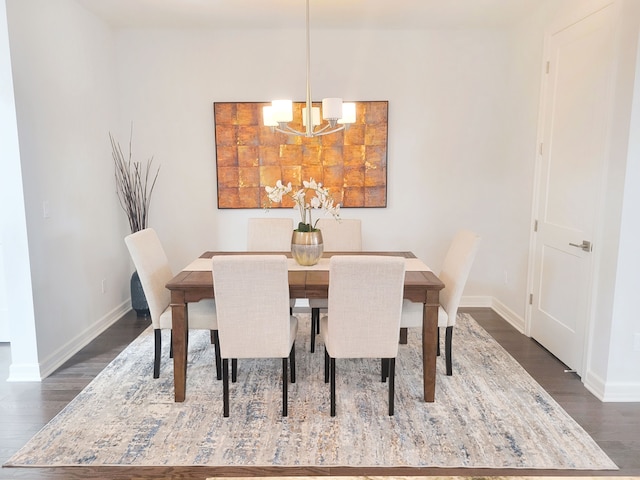 dining room with dark wood-type flooring and an inviting chandelier