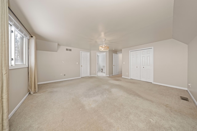 additional living space with vaulted ceiling and light carpet