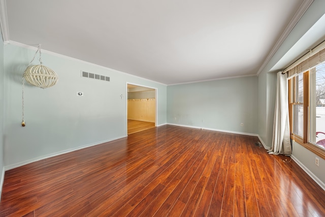 empty room featuring dark wood-type flooring and ornamental molding