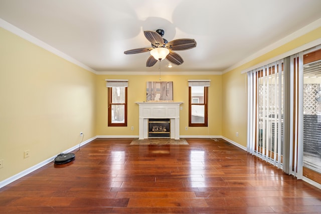 unfurnished living room featuring a healthy amount of sunlight, dark hardwood / wood-style floors, and ornamental molding