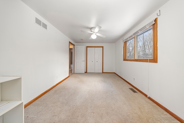 spare room with ceiling fan and light carpet