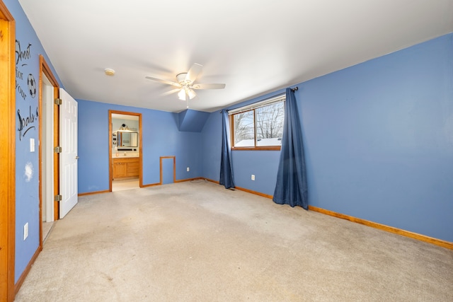 unfurnished bedroom featuring ceiling fan, ensuite bath, and light carpet