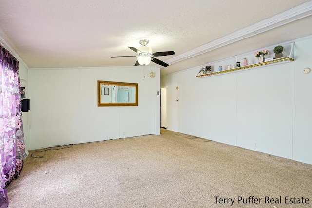 empty room with ceiling fan, carpet, ornamental molding, and a textured ceiling