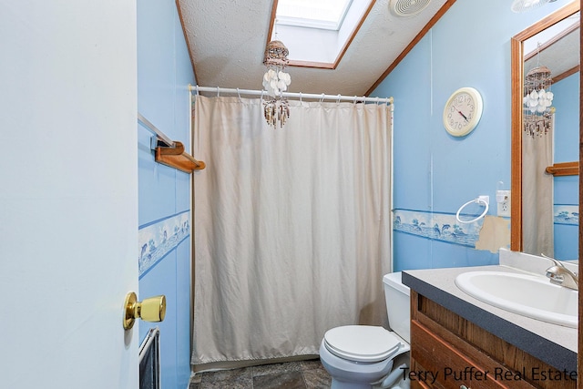 bathroom featuring a skylight, a shower with shower curtain, vanity, a textured ceiling, and toilet