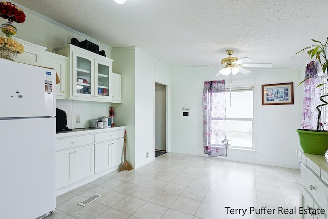 kitchen with white cabinetry, a textured ceiling, ceiling fan, and white refrigerator