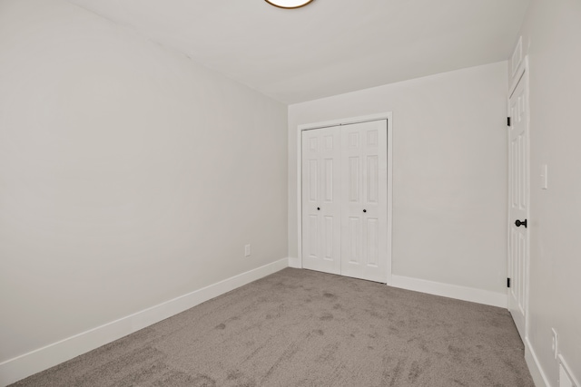 unfurnished bedroom featuring carpet flooring and a closet