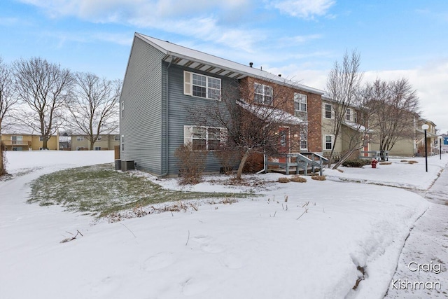 snow covered rear of property with central AC