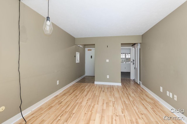 unfurnished living room with baseboards and light wood-style floors