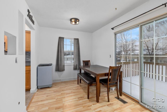 dining space featuring baseboards, light wood-style floors, and visible vents