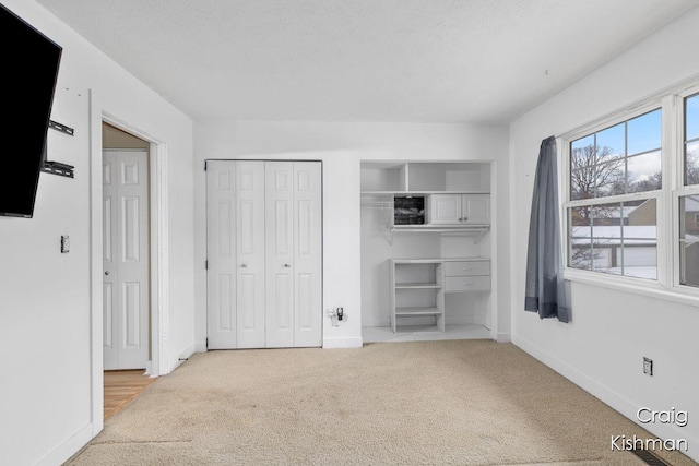 unfurnished bedroom featuring carpet floors, multiple closets, and baseboards