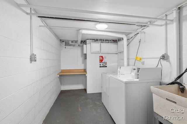 common laundry area with washing machine and clothes dryer, concrete block wall, and a sink
