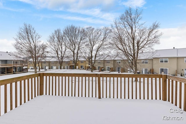 snow covered deck with a residential view