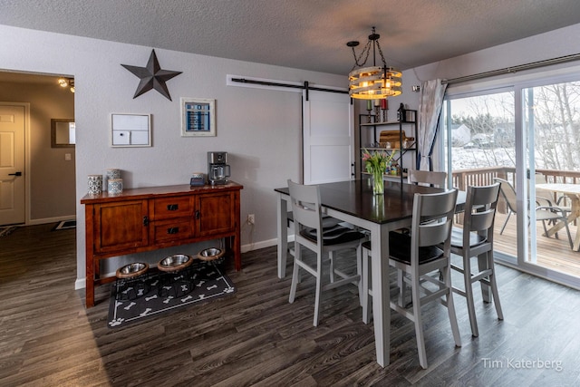 dining area featuring dark hardwood / wood-style floors, a barn door, and a textured ceiling