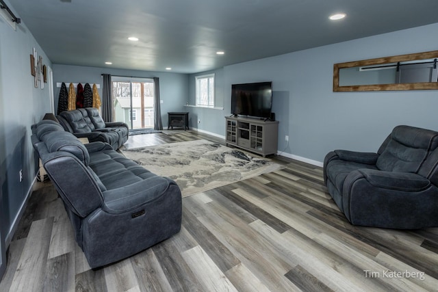 living room with a barn door and hardwood / wood-style floors