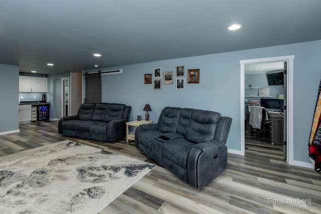 living room with wine cooler, a barn door, and hardwood / wood-style floors