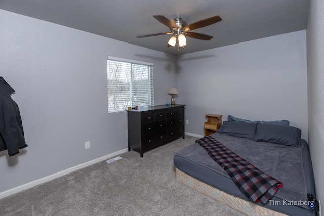 carpeted bedroom featuring a textured ceiling and ceiling fan