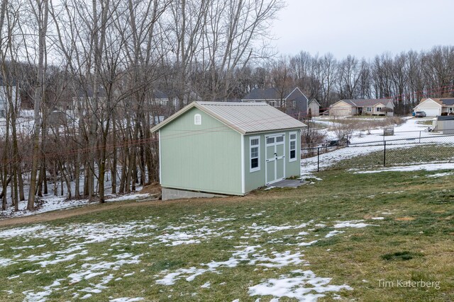 snow covered structure with a lawn