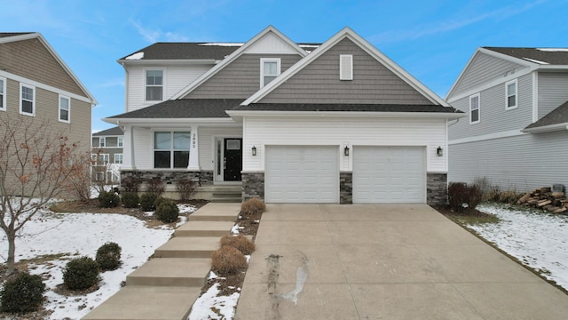 craftsman-style home with stone siding, an attached garage, and driveway