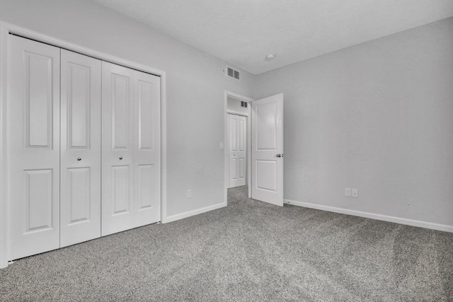 unfurnished bedroom featuring a closet, carpet flooring, visible vents, and baseboards