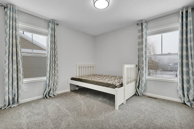 carpeted bedroom featuring visible vents and baseboards