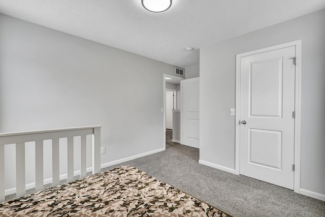 unfurnished bedroom with carpet floors, visible vents, and baseboards