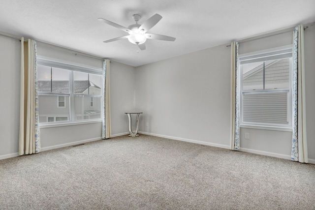 carpeted spare room with visible vents, ceiling fan, a textured ceiling, and baseboards