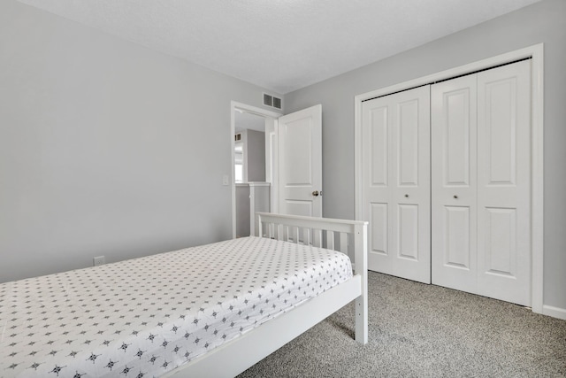 carpeted bedroom featuring a closet and visible vents