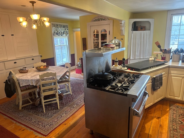 kitchen with pendant lighting, a notable chandelier, white cabinetry, and dark hardwood / wood-style floors