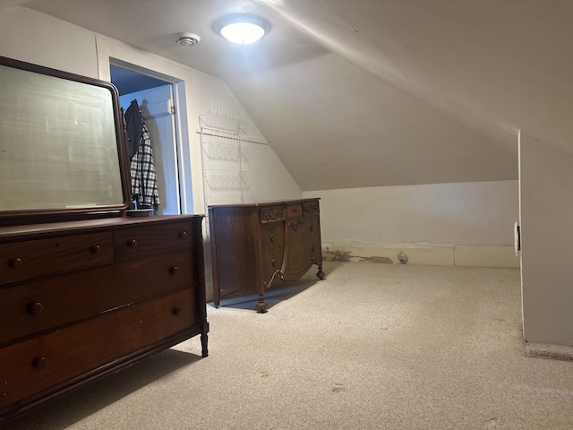 additional living space with light colored carpet and lofted ceiling