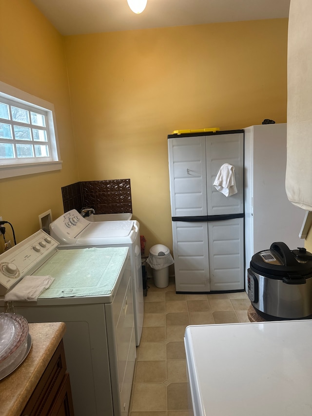 laundry area with cabinets, light tile patterned floors, and washer and clothes dryer