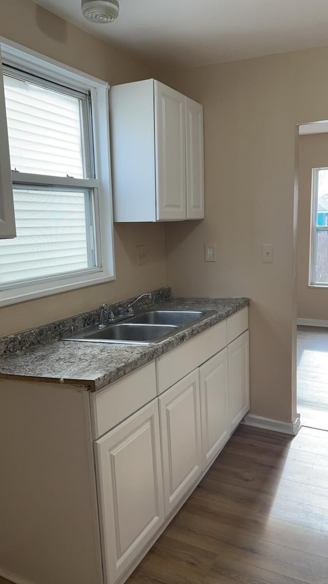 kitchen featuring white cabinetry, sink, and dark hardwood / wood-style floors