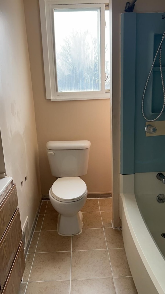 bathroom featuring tile patterned flooring, a bath, vanity, and toilet