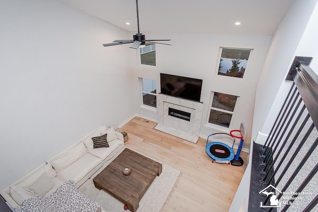 living room featuring ceiling fan, a fireplace, and hardwood / wood-style floors