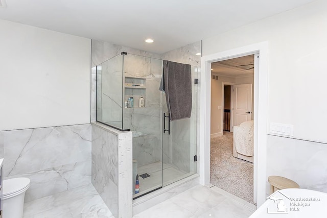 bathroom featuring an enclosed shower, tile walls, and toilet