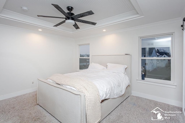 carpeted bedroom featuring ceiling fan, ornamental molding, and a raised ceiling