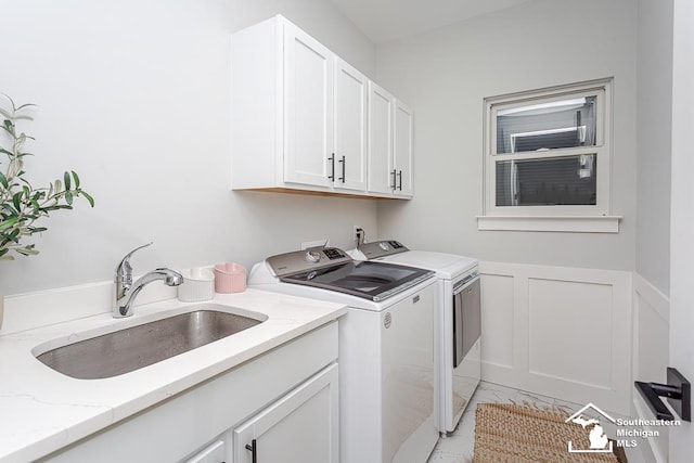 laundry room featuring cabinets, sink, and washer and dryer