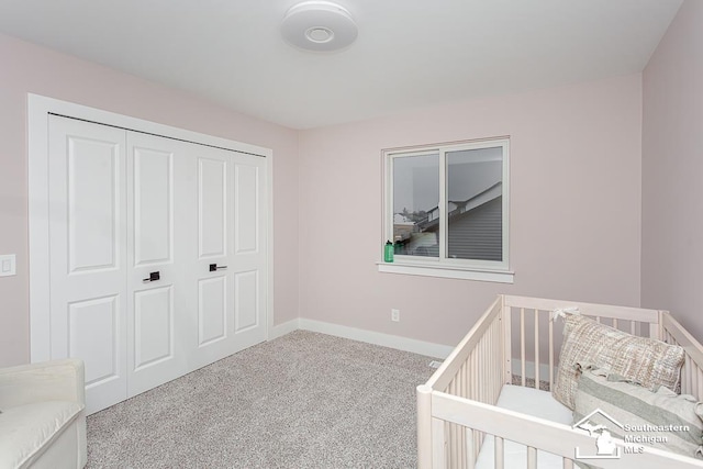 carpeted bedroom with a closet and a nursery area