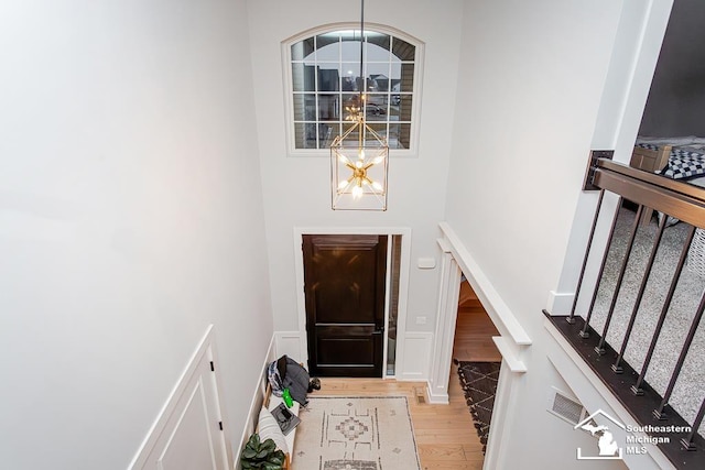 foyer entrance featuring light hardwood / wood-style flooring and a notable chandelier