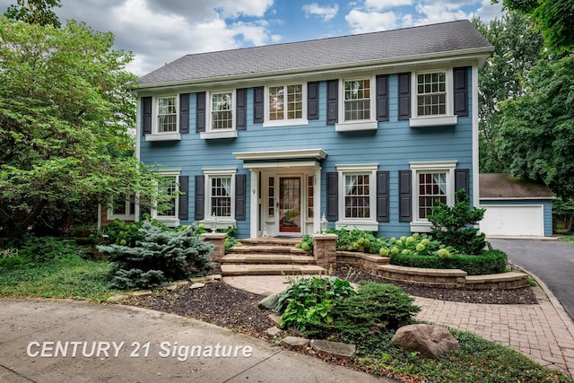 colonial home with a garage and an outdoor structure