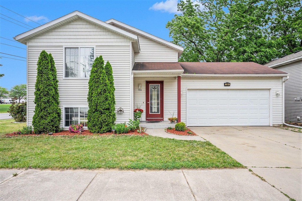 tri-level home with a garage and a front yard