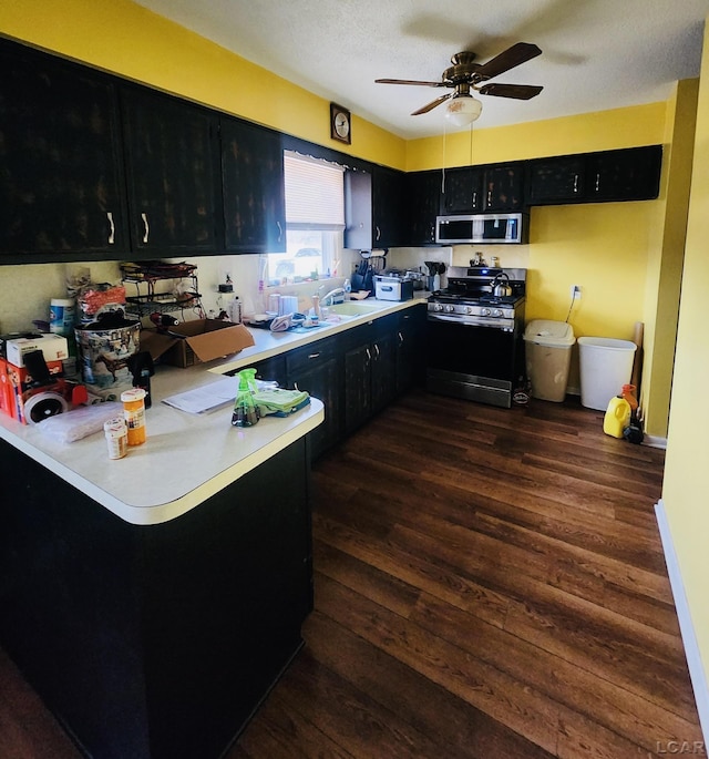 kitchen featuring sink, dark wood-type flooring, stainless steel appliances, and ceiling fan