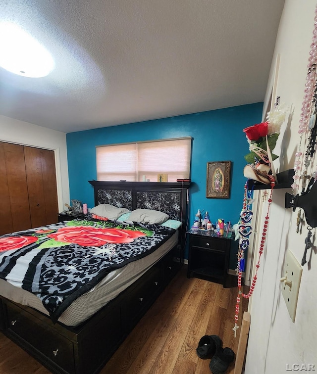 bedroom featuring hardwood / wood-style flooring, a closet, and a textured ceiling