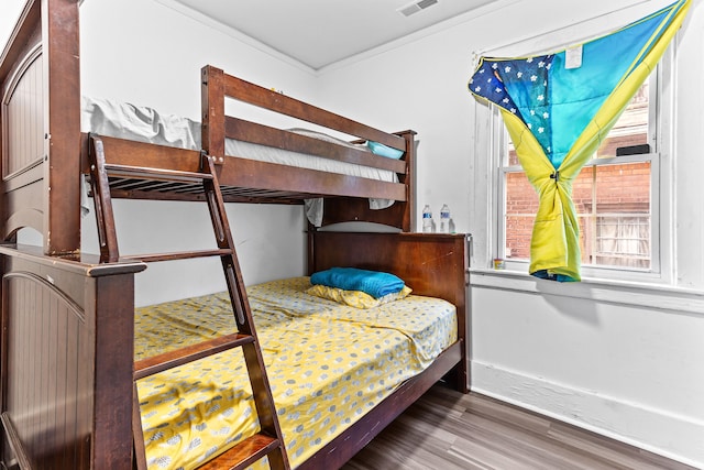 bedroom with ornamental molding and dark hardwood / wood-style floors