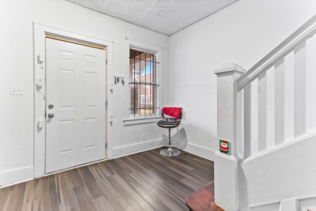 foyer entrance with wood-type flooring and a textured ceiling