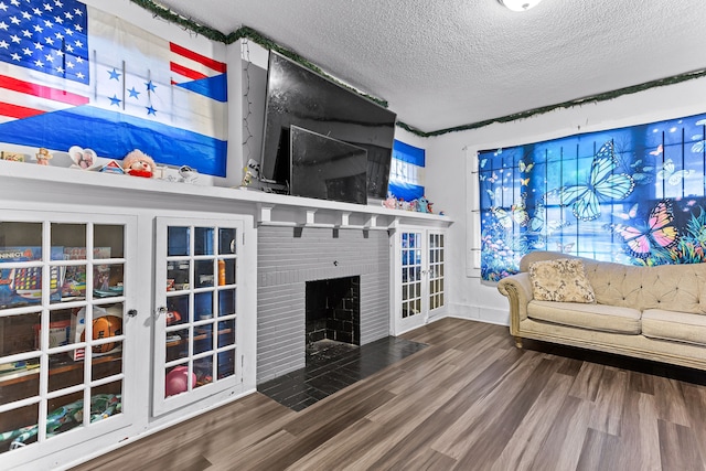 unfurnished living room with hardwood / wood-style flooring, a brick fireplace, and a textured ceiling